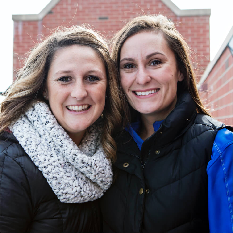 2 girls wearing a scarf and a vest